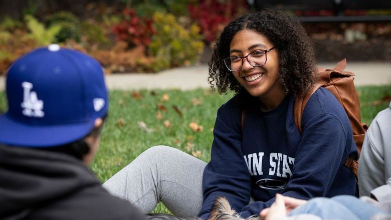 Woman in Penn State sweatshirt talking to other students
