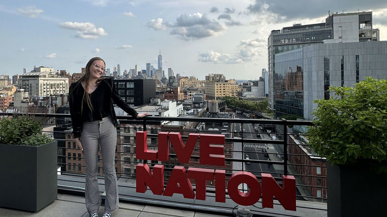 Woman standing on rooftop next to a Live Nation sign