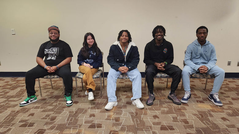 5 students sitting in chairs 