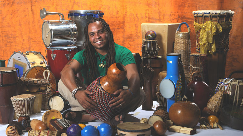 Dendê seated around instruments