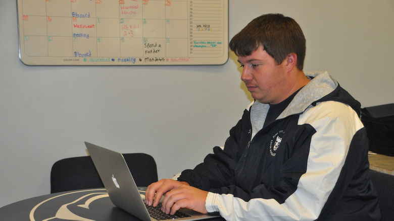 student typing on laptop