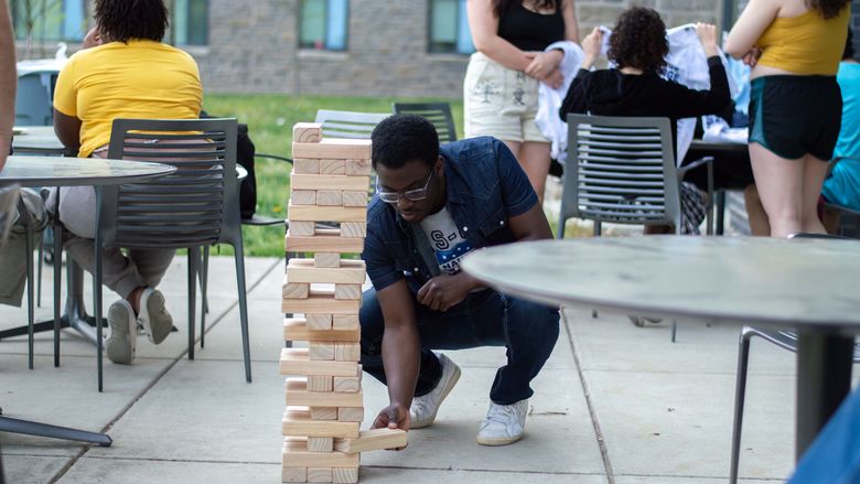 student playing Jenga outside