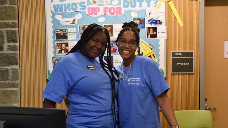 Two students smiling at the front desk of lions gate