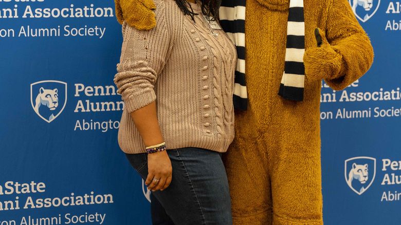 Alumni taking a photo with Nittany Lion
