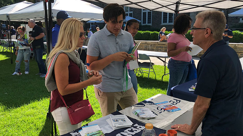student and parent at a table at new student orientation 