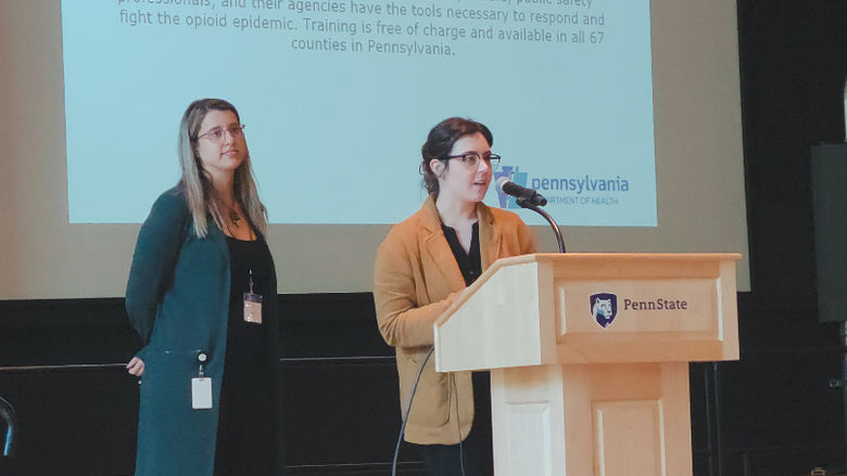 Heather Myers and Zoe Miner presenting at the podium.