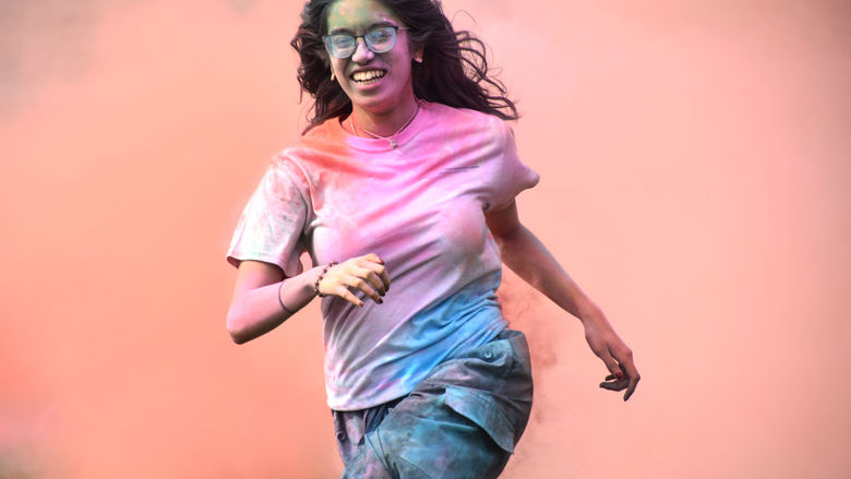 Penn State Abington student celebrates Holi by running through clouds of chalk