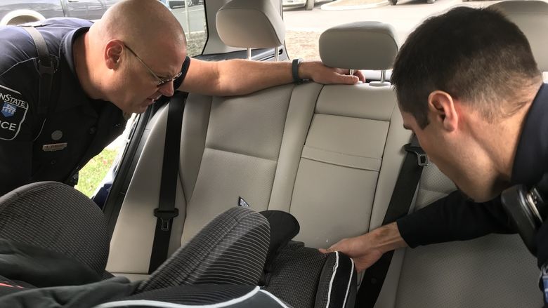 officers inspect child safety seat