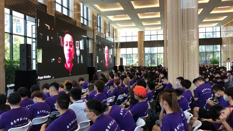 A group of students in a large hall for orientation