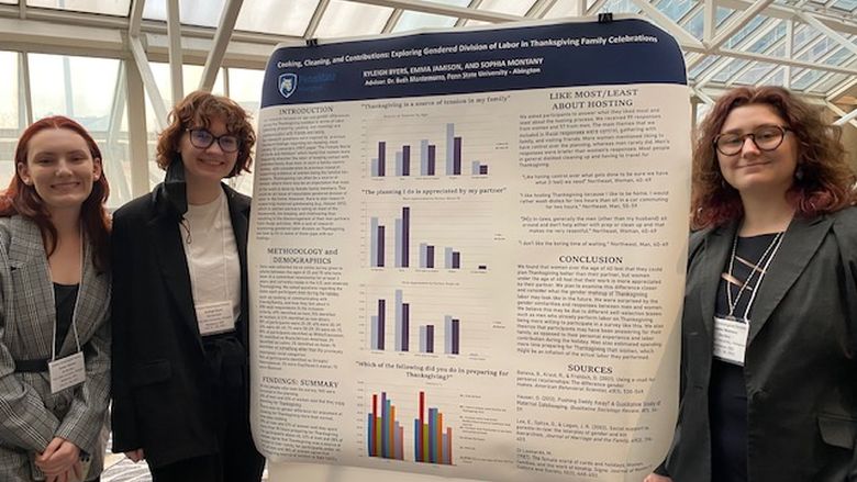 Three PSS major students standing in front of poster board project