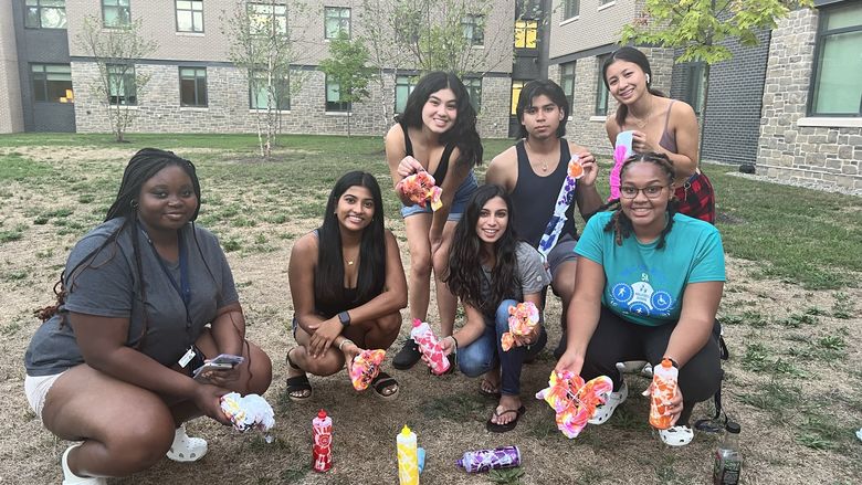 students holding tie dye t shirts
