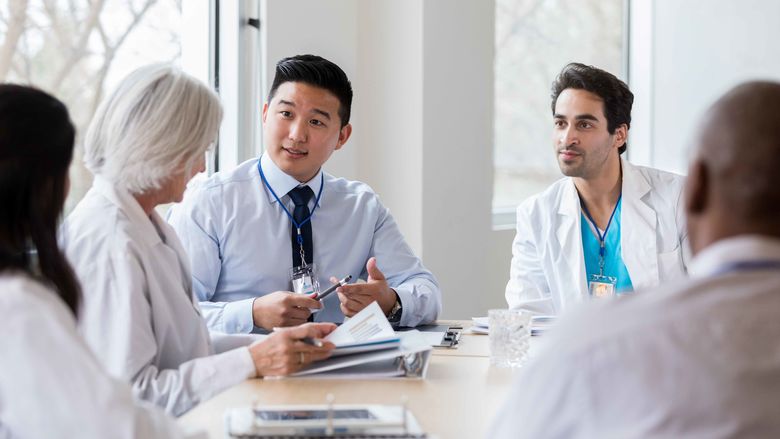 student and doctors talking at a table