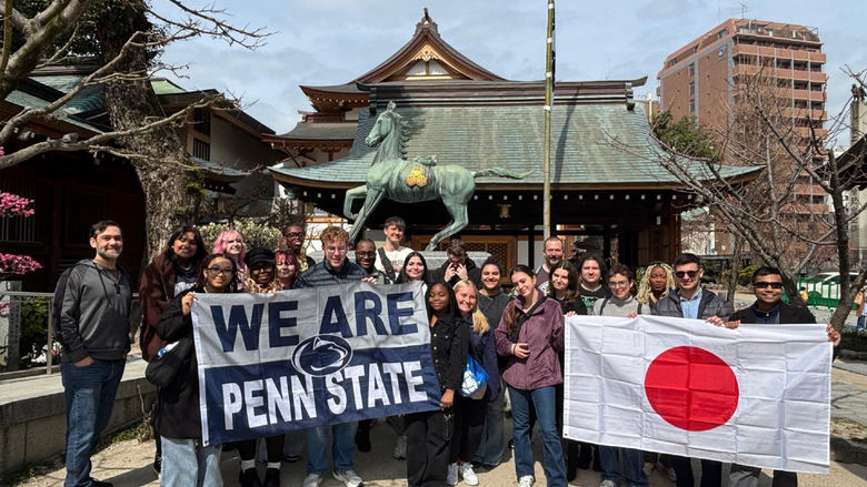 People holding Penn State and Japanese flags