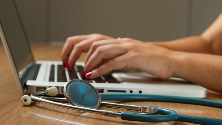 Medical examiner adding data on a laptop