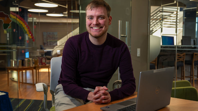 Master of AI student Nicholas Gahman sits at a desk in front of a laptop in Penn State Great Valley's Technology Commons.