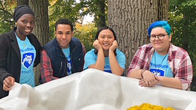 four students around the Lion