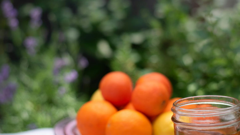 Mason jar with tea and oranges and cinnamon on table