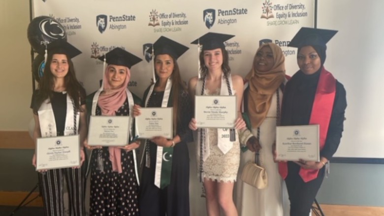 tri-alpha students smiling with grad caps