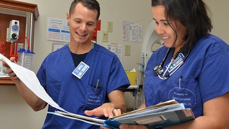 two nurses talking and looking at papers
