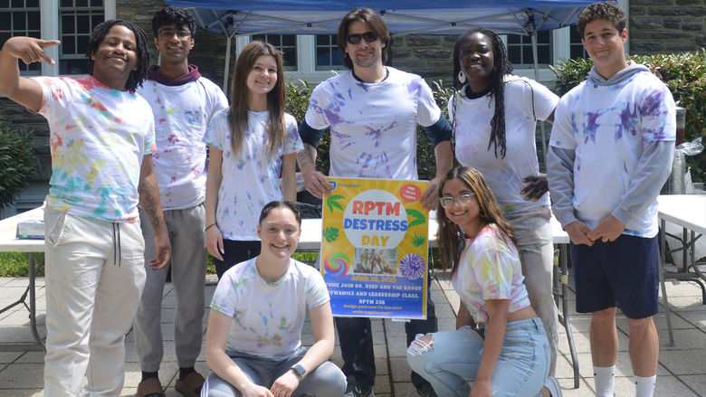 Students in front of a building with a sign