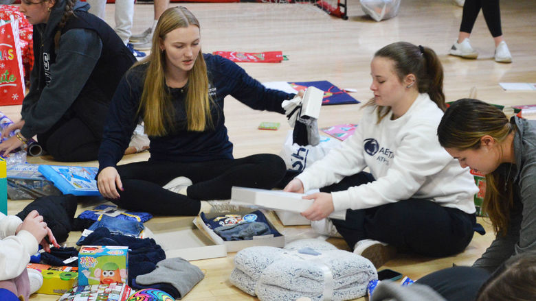 Penn State Abington student athletes wrap gifts for a family in need