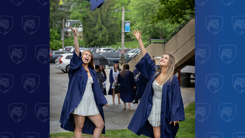 Two women throwing graduation caps in the air