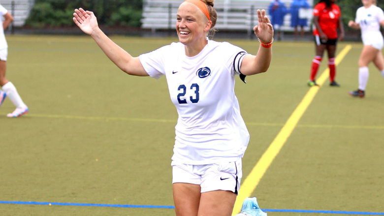 Woman's soccer player with arms raised