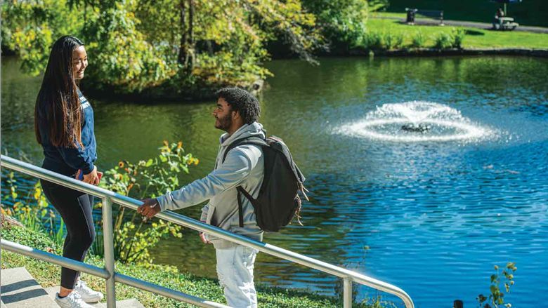 Students talking by pond