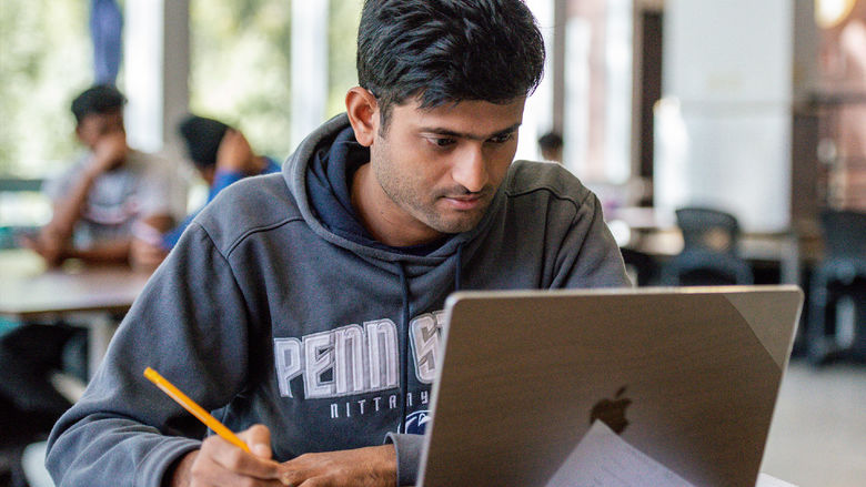 Student sitting at desk with laptop