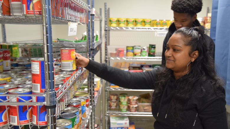 student placing can on shelf