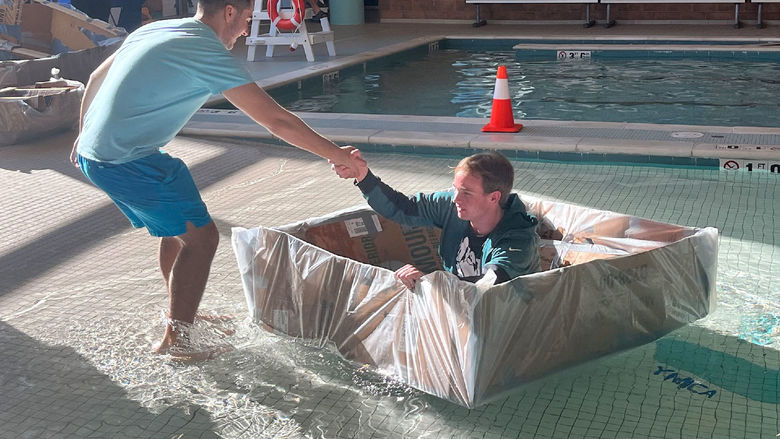 Students launching a boat at the Cardboard Regatta.