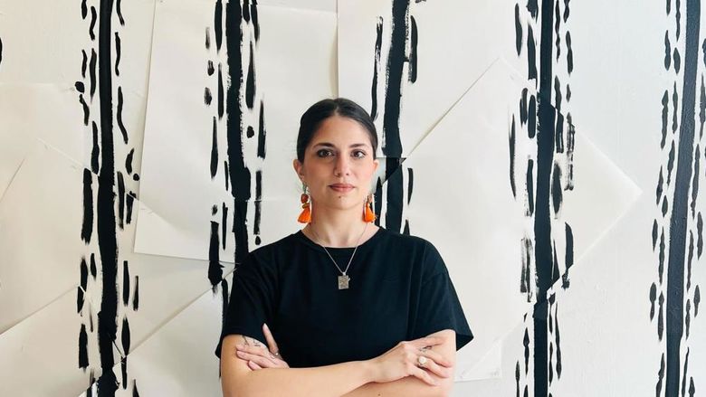 Person standing in front of white wall with black lines