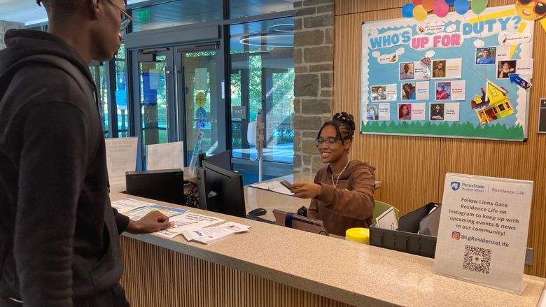 Student working front desk at Lions Gate