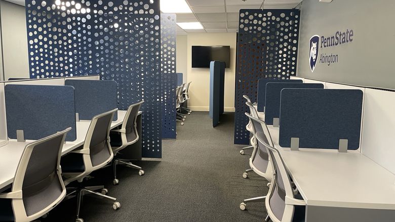 A large room with individual workstations and sound dividers