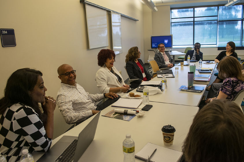 A team from Penn State Harrisburg talks while sitting around a large conference table