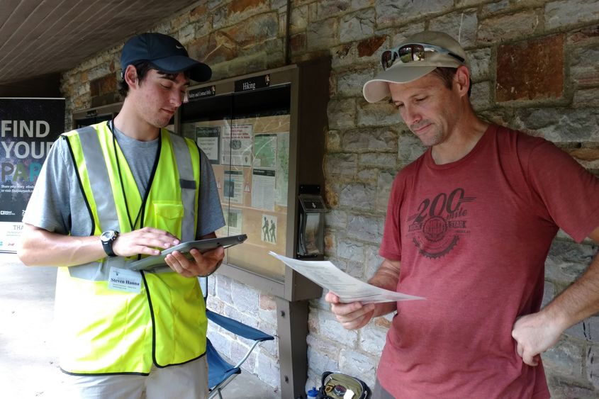 A research team member surveys a park visitor