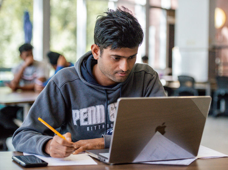 Student sitting at desk with laptop