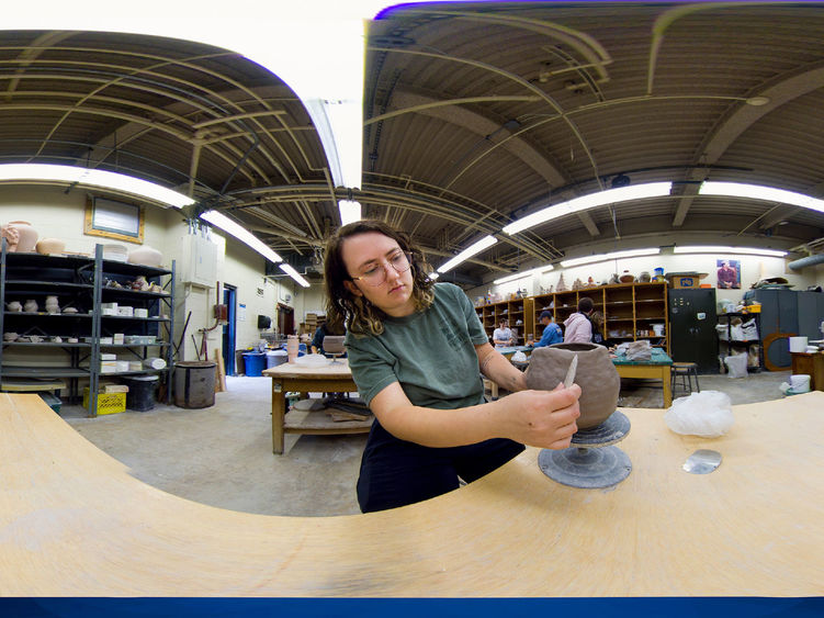 Panoramic view of student sculpting in an art studio